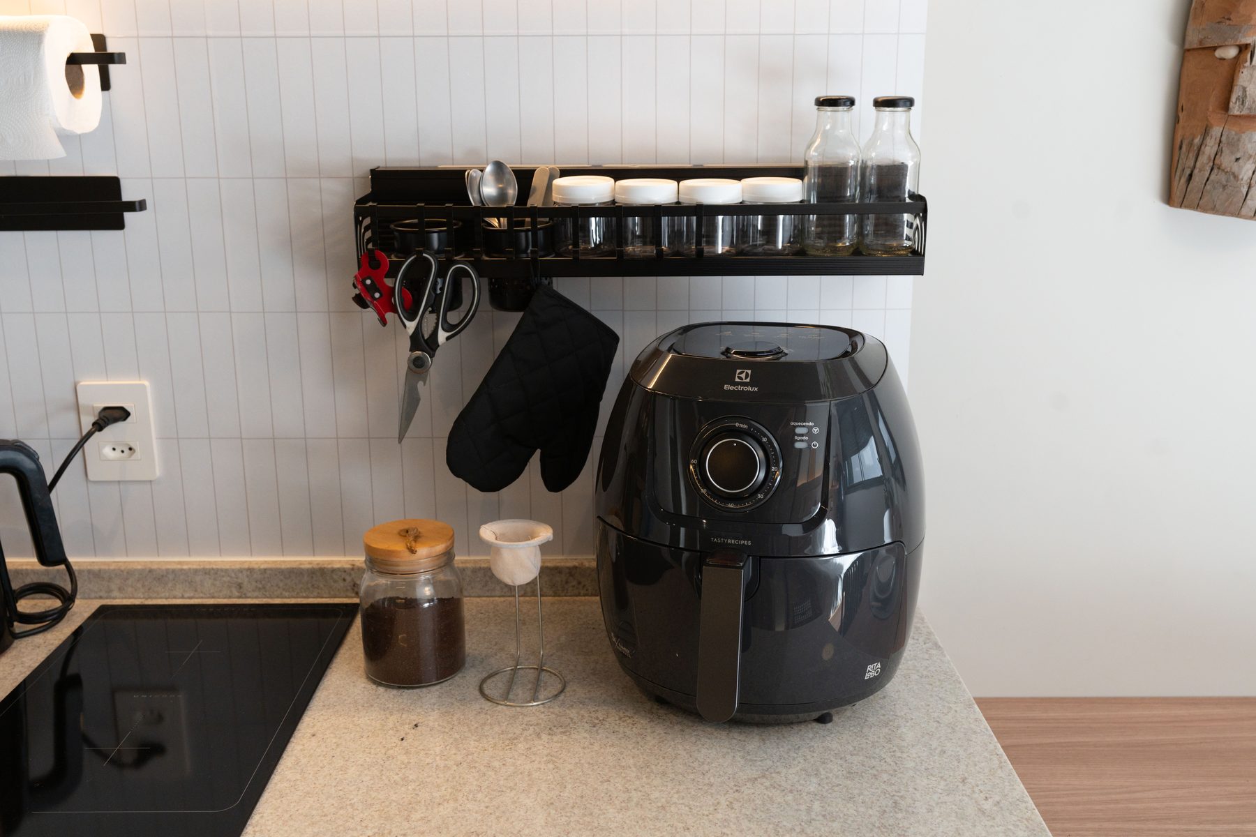 Air fryer na bancada da cozinha, com porta-temperos e luva térmica